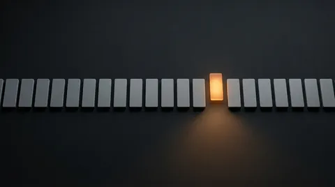 A long row of identical pale-grey upright tiles on a charcoal background, with a single tile in the centre glowing warm orange — the only one lit, casting an amber glow on the surface below it.