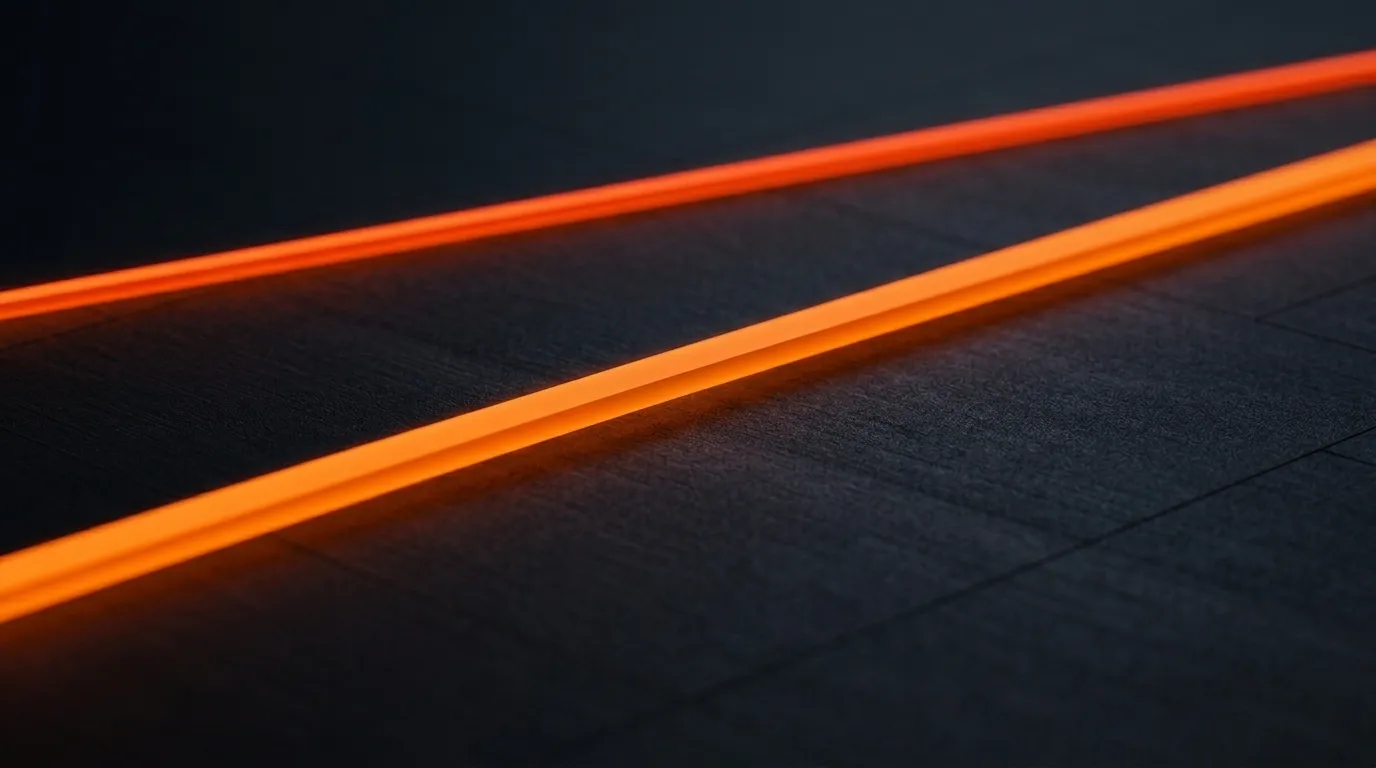 A single unbroken glowing orange line running diagonally across a dark, textured charcoal surface.